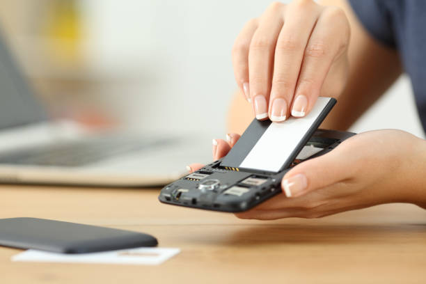Close up of a woman hand putting a battery into a smart phone